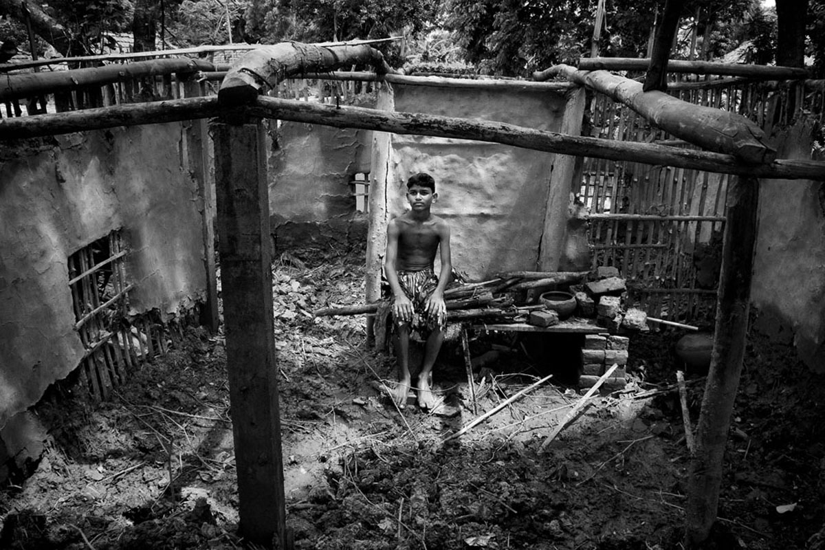 Suraj Jamal Mallick, 12, a student of grade VI sits in front of his broken house. Every year, with every new inch shrinking, several people in the Island is becoming homeless. These people have been termed ?environmental refugees?.
