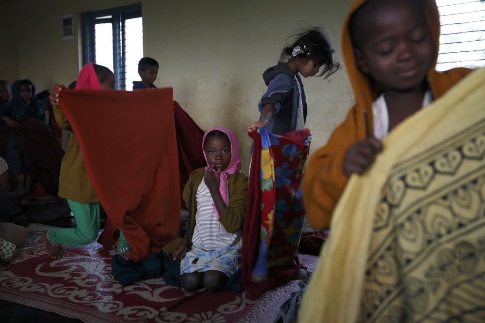 School children wake up after sleeping on their classroom floor at a Christian run missionary school located next to the village of Gadgera. Uttara Kanada, India